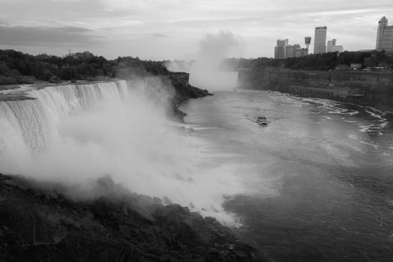 A black and white photo of the falls. The US falls are seen on the left and the horseshoe falls are seen in the distance.