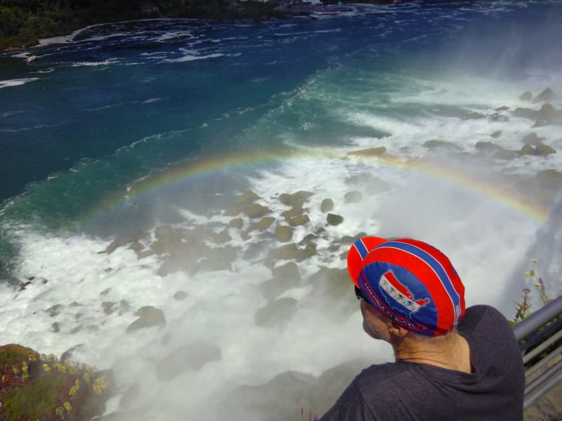 Chris listens to the crashing of the US falls. There is a rainbow around his head.