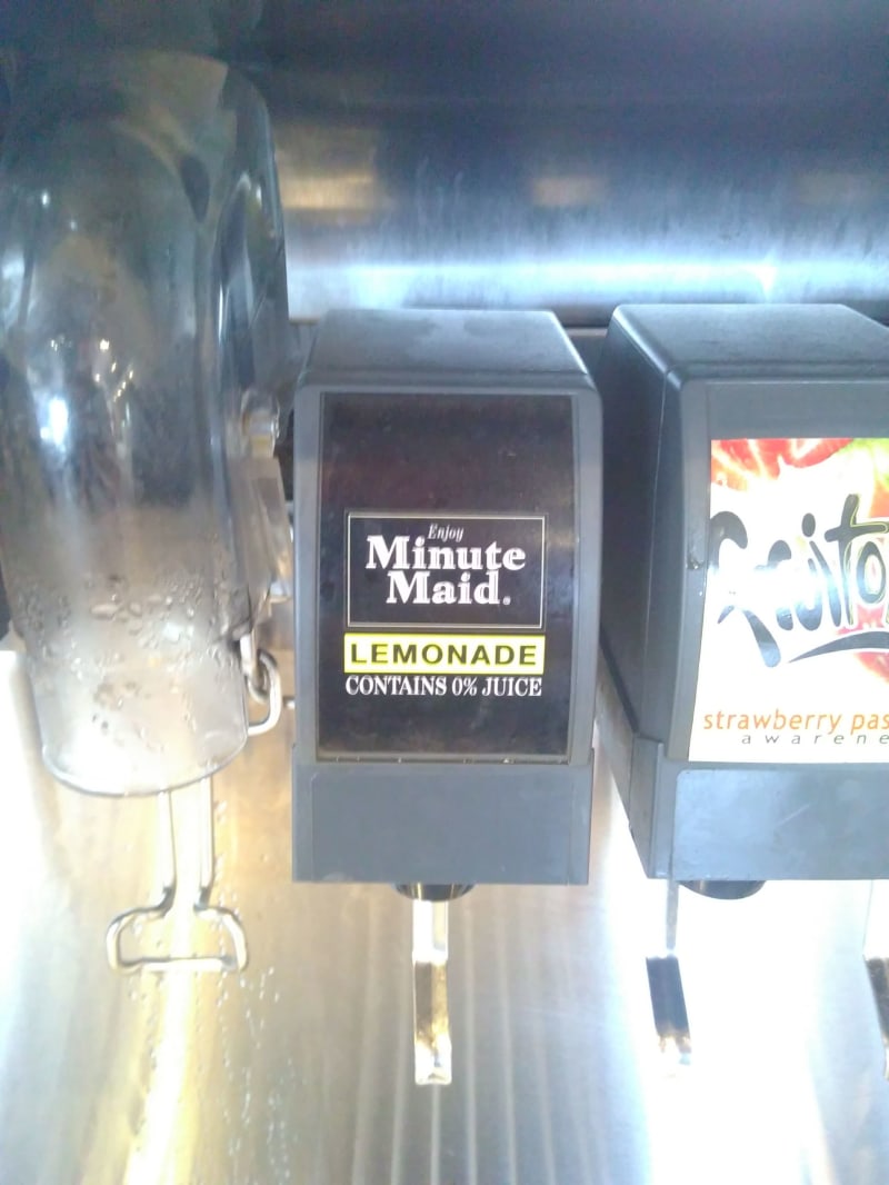 A drinks dispenser. The label reads: "Minute Maid Lemonade, 0% Juice"